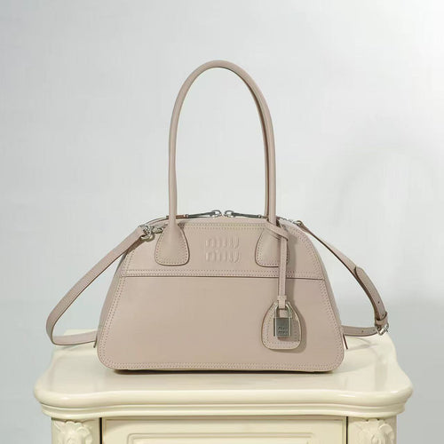 Beige dome-shaped bag with elongated twin handles, shoulder strap and silver-tone hardware