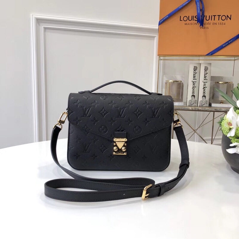 Black embossed top-handle bag with shoulder strap and gold-tone clasp