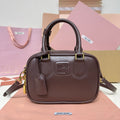 Dark brown rounded rectangular bag with twin top handles, shoulder strap and gold-tone hardware