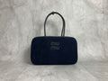 Dark navy vertically ribbed bag with rounded rectangular silhouette and elongated twin handles