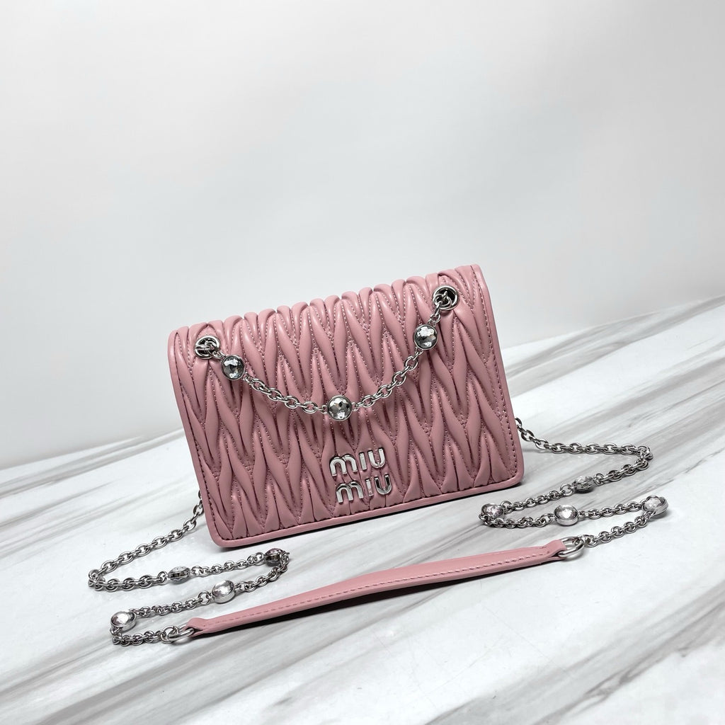Dusty pink ruched shoulder bag with silver-tone chain strap and faceted decorative accents